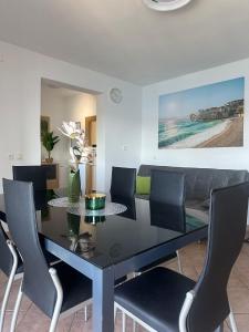 a dining room with a black table and chairs at Apartman Majba 2 in Zaglavice