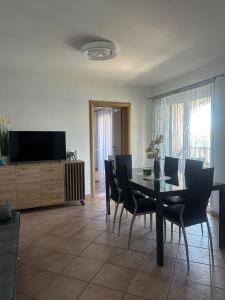 a dining room with a table and chairs and a television at Apartman Majba 2 in Zaglavice