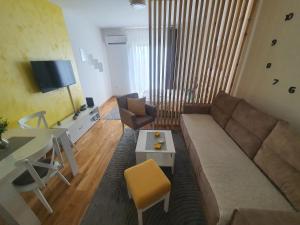 Vrnjačka BanjaにあるApartman IRISのソファとテーブルのあるリビングルーム