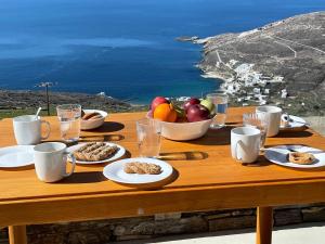 Una mesa de madera con platos de comida sobre una mesa con vista. en Casa Ostria, en Istérnia