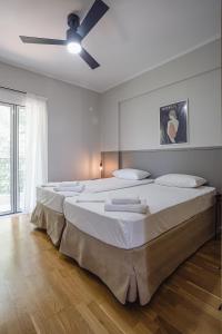 a bedroom with two beds and a ceiling fan at NIMA Village in Paleros +25 photos