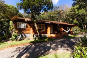 a wooden house with a tree in front of it at Casa da Mata in São Bento do Sul