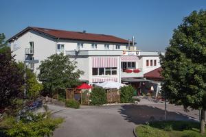 ein großes weißes Gebäude mit rotem Dach in der Unterkunft Sporthotel Öhringen in Öhringen