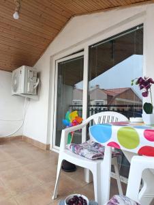 a table and chairs on a patio with a window at Rooftop rooms Ohrid in Ohrid
