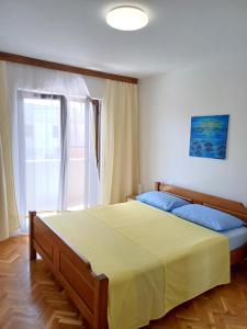 a bedroom with a large bed and a window at Apartmani Saška 1 in Privlaka