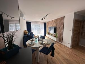 salon ze stołem i krzesłami w obiekcie Solar Baltic Apartament by Resort&SPA Porta Mare Dziwnów w Dziwnowie