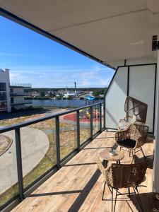 balkon z 2 krzesłami i stołem na tarasie w obiekcie Solar Baltic Apartament by Resort&SPA Porta Mare Dziwnów w Dziwnowie