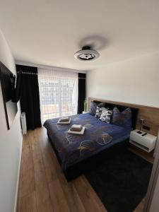 sypialnia z łóżkiem z niebieską kołdrą w obiekcie Solar Baltic Apartament by Resort&SPA Porta Mare Dziwnów w Dziwnowie +22 zdjęcia