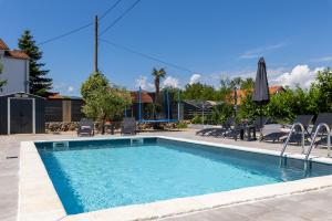 a swimming pool with chairs and an umbrella at Villa ZaVaLa Brzac in Brzac