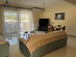 a living room with a couch and a tv at Luxury View in Iraklitsa