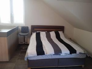 a bedroom with a bed and a blue chair at Merunky pod Palavou in Šakvice