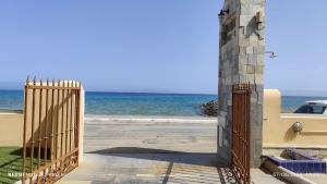 a gate to the beach with the ocean in the background at Niros Beachfront Aparthotel in Kokkíni Khánion