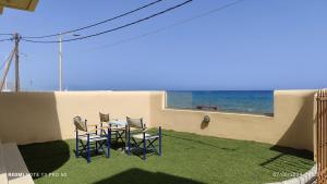 a patio with a table and chairs and the ocean at Niros Beachfront Aparthotel in Kokkíni Khánion