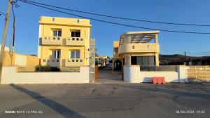 a yellow apartment building in front of a street at Niros Beachfront Aparthotel in Kokkíni Khánion