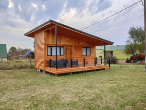a log cabin with a deck in a yard at El ranchito in Colón +11 photos