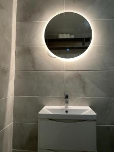 a bathroom with a white sink and a mirror at Double Room with Deluxe Bathroom in Southbourne