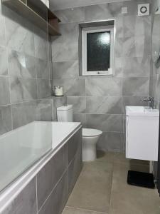 a bathroom with a tub and a toilet and a sink at Double Room with Deluxe Bathroom in Southbourne
