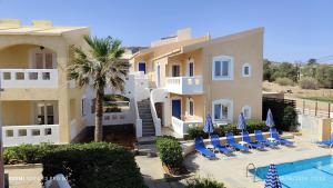 a view of a building with chairs and a swimming pool at Niros Beachfront Aparthotel in Kokkíni Khánion