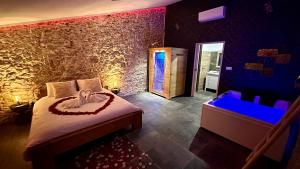 a bedroom with a bed and a tub in a room at Loft Romantique la Clef des Sens - Sauna et Balnéo privatifs in Tourves