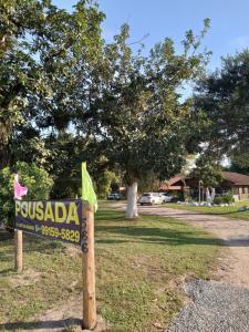 ein Schild mit der Aufschrift „Pussada“ vor einem Park in der Unterkunft Pousada Araquari Hostel in Paraty