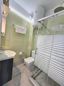 a bathroom with a shower and a toilet and a sink at Breeze Beach Apartment Glyfada in Corfu