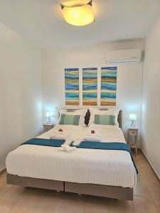 a bedroom with a large white bed in a room at Breeze Beach Apartment Glyfada in Corfu