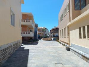 an empty alley between two buildings in a city at Niros Beachfront Aparthotel in Kokkíni Khánion