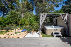 a backyard with a hot tub and a palm tree at Superbe villa, piscine chauffée, jacuzzi in Lecci