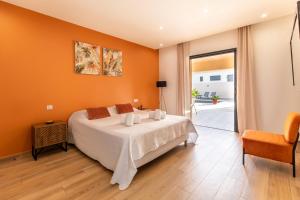 a bedroom with a white bed and an orange wall at Superbe villa, piscine chauffée, jacuzzi in Lecci +15 photos