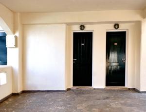 two black doors on a white wall in a room at Niros Beachfront Aparthotel in Kokkíni Khánion