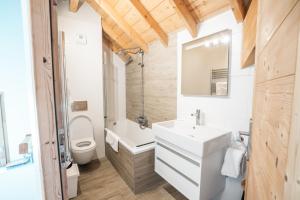 a bathroom with a white sink and a toilet at Large private chalet in Vaujany in Vaujany +49 photos