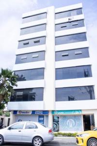 a white car parked in front of a building at Condo In El Murcielago Beach in Manta