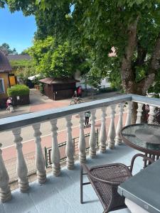 a balcony with a white railing and a table and chairs at NB Apartamentai in Palanga