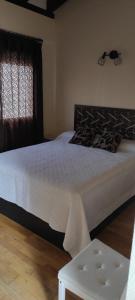 a bedroom with a white bed and a window at Casa rural La Abuela in El Ronquillo