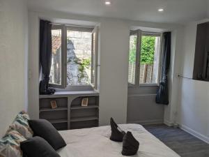 une chambre avec un lit et deux fenêtres dans l'établissement Studio de Tokyo, à Montbéliard