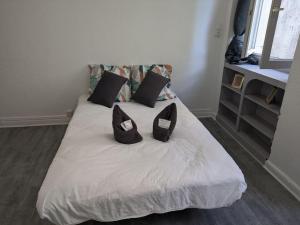 - un lit avec 2 oreillers noirs dans l'établissement Studio de Tokyo, à Montbéliard