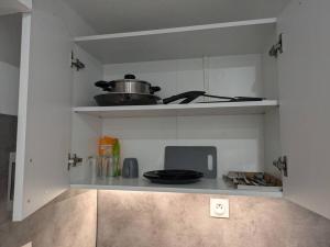 - une cuisine avec une cuisinière et une étagère dans l'établissement Studio de Tokyo, à Montbéliard