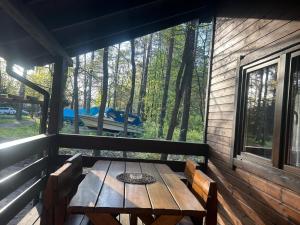 a wooden table sitting on the porch of a cabin at Domek letniskowy Chrząszczów w Małej Rusi ARIZONA in Kajkowo