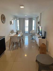 a living room with a table and chairs and a television at Solares de araus, apartamento in Colonia del Sacramento