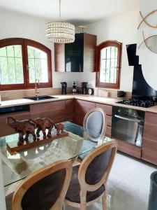 a kitchen with a glass table and two chairs at Maison avec jardin 6 min du RER in Villiers-sur-Marne