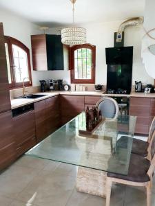 a kitchen with a glass table and a chair at Maison avec jardin 6 min du RER in Villiers-sur-Marne +1 photo