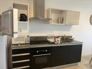a kitchen with a black and white counter top at Solares de araus, apartamento in Colonia del Sacramento