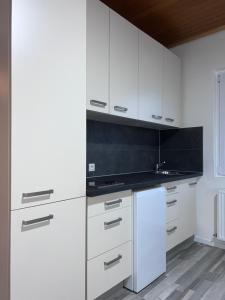 a kitchen with white cabinets and a white refrigerator at ROYAL RACiING SUITE TOP 4 in Judenburg +7 photos