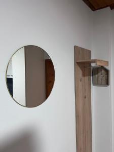 a round mirror on a wall with a wooden shelf at ROYAL RACiING SUITE TOP 4 in Judenburg