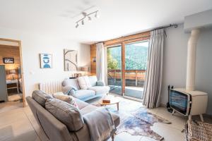 a living room with a couch and a tv at Large private chalet in Vaujany in Vaujany