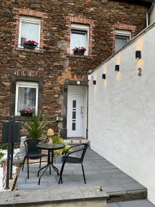 a patio with a table and chairs in front of a building at Ada&Cris Apartament in Klotten