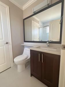 a bathroom with a toilet and a sink and a mirror at Near Skytrain and QUIET Private Bedroom Ensuite BathRM, Free Wifi & Coffee, Cozy in Burnaby +18 photos