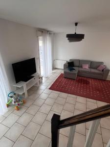 a living room with a couch and a flat screen tv at Grande Maison proche Paris 10 12 personnes in Bagnolet