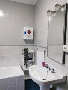 a white bathroom with a sink and a mirror at Casa Rural La Barranca in Cuevas del Becerro +16 photos