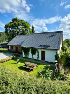 a white house with a picnic table in the yard at Apartmány no.823 in Bublava
